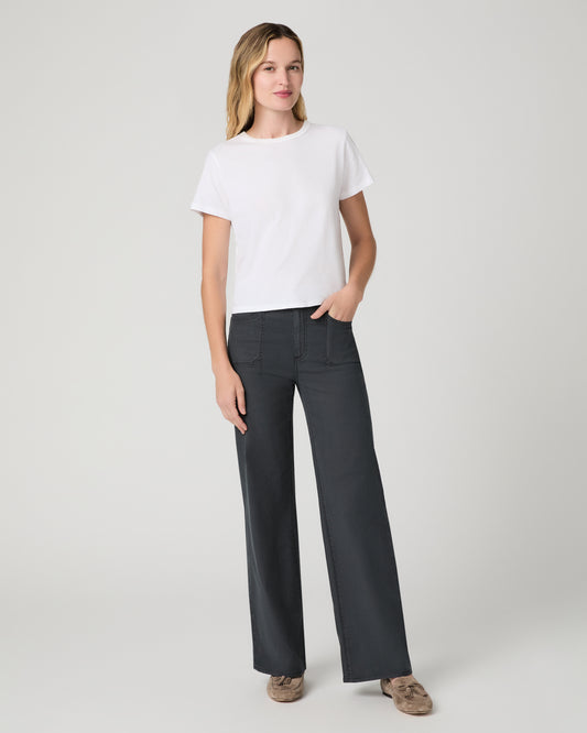 Women wearing a white tee and grey pants paired with brown flats against a white background