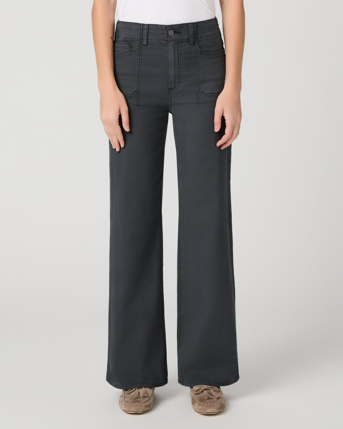Women wearing a white tee and grey pants paired with brown flats against a white background