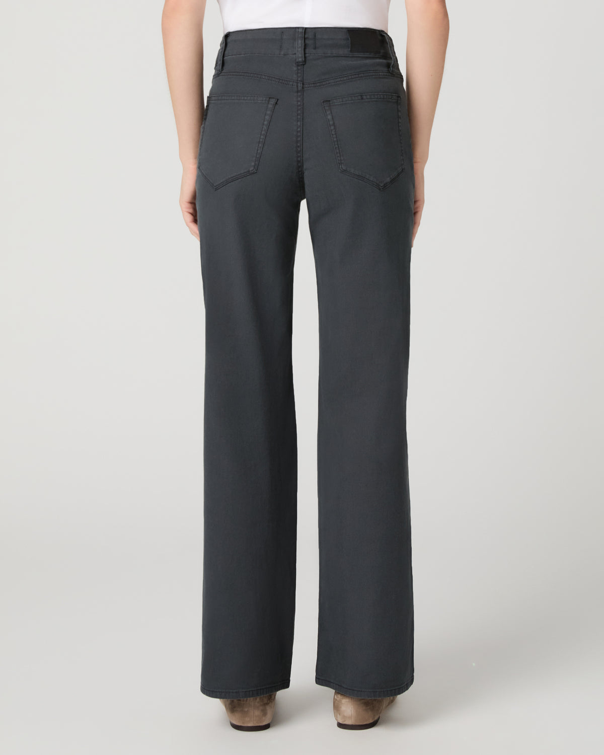 Women wearing a white tee and grey pants paired with brown flats against a white background