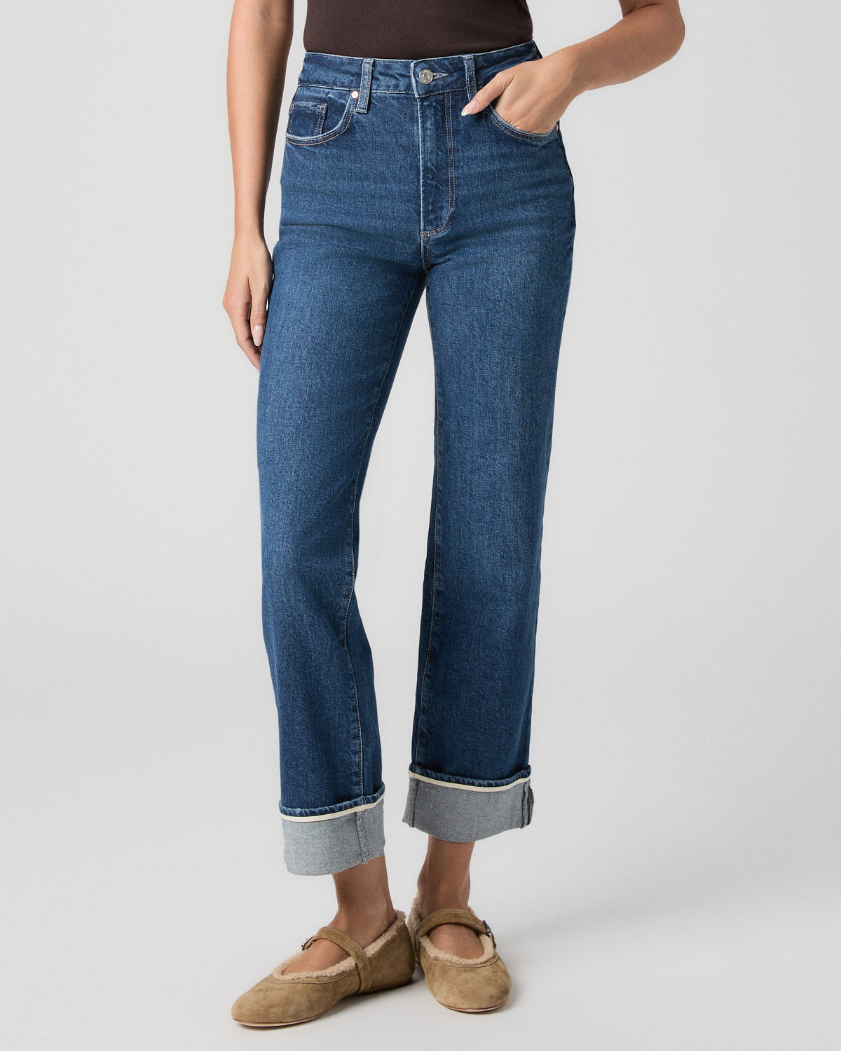 Front view from the waist down of the Stevie Straight Jean in Soundcheck dark wash, showing the wide cuffs, with one hand in the pocket and tan suede flats