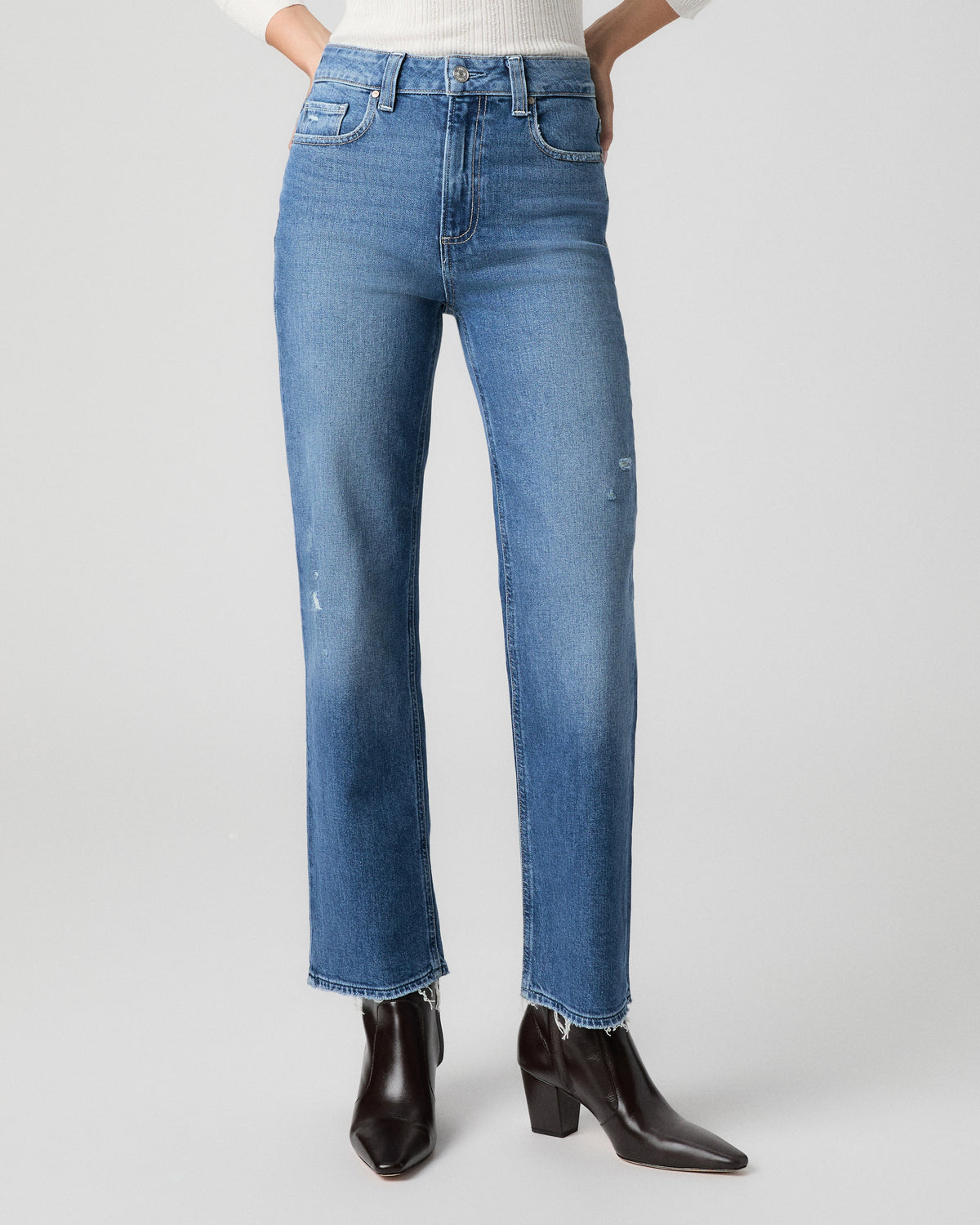 Front view from the waist down of the Stevie Ankle Straight Jean in Frittata Dest light-medium wash, showing light distressing, with black ankle boots