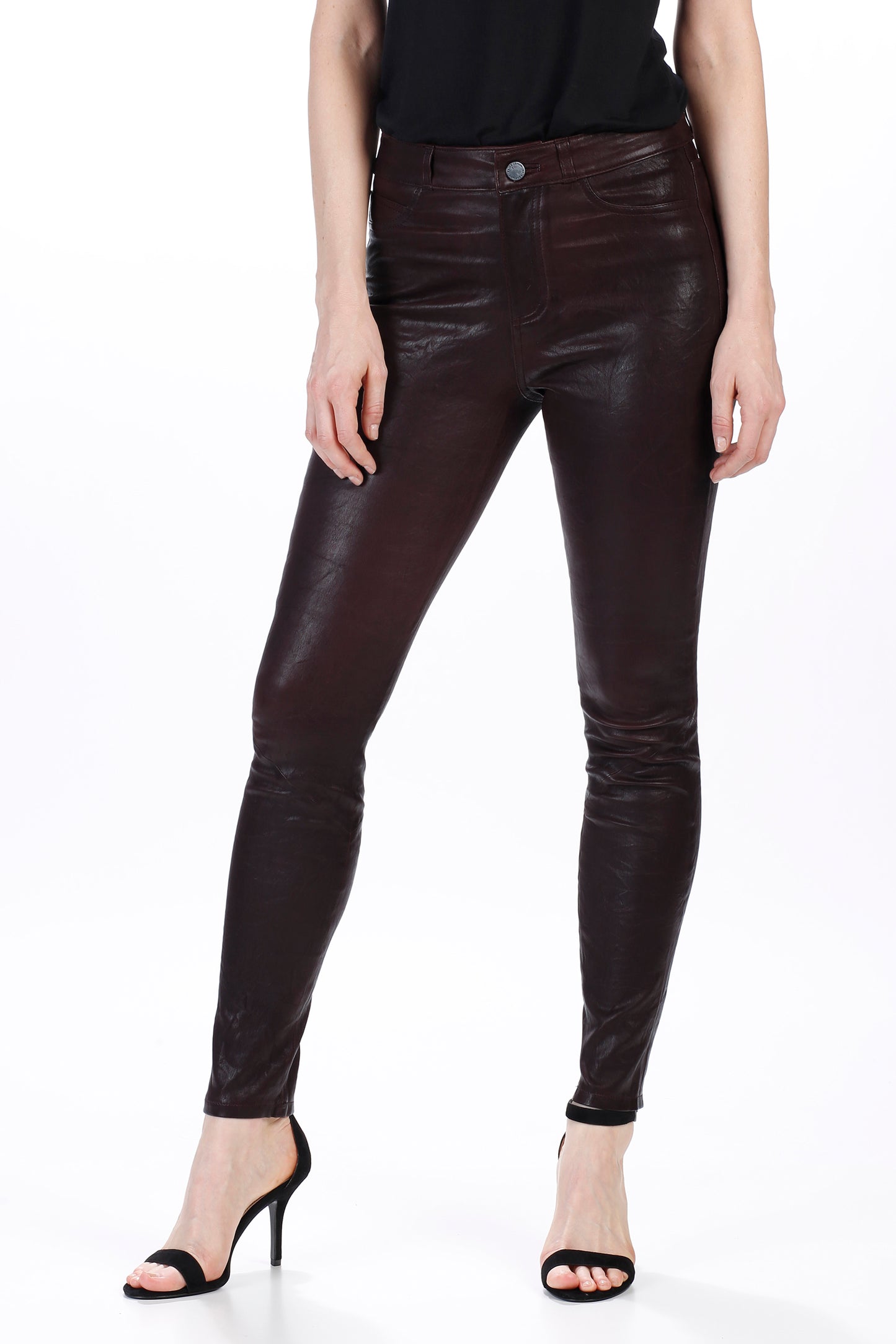 Person wearing dark brown leather pants on a white background