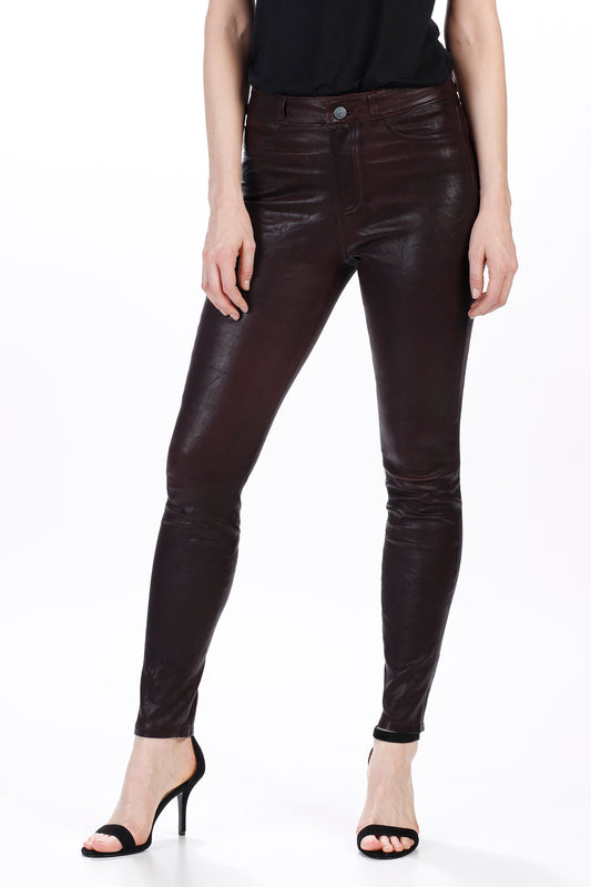 Person wearing dark brown leather pants on a white background