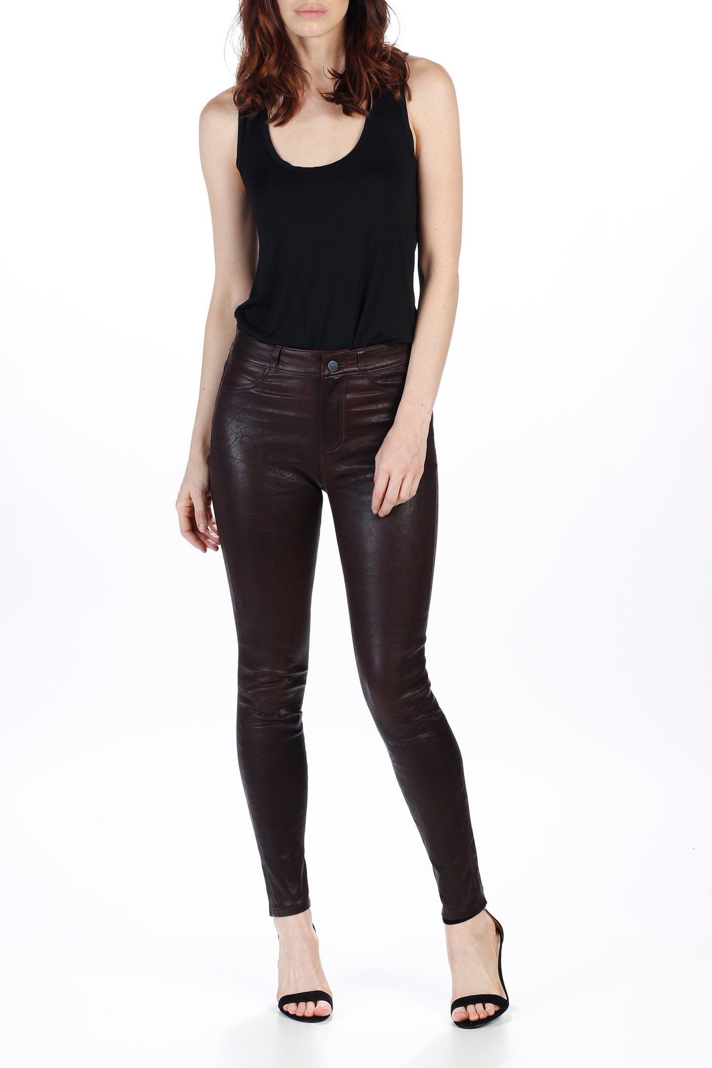 Person wearing black tank top and leather pants on a white background