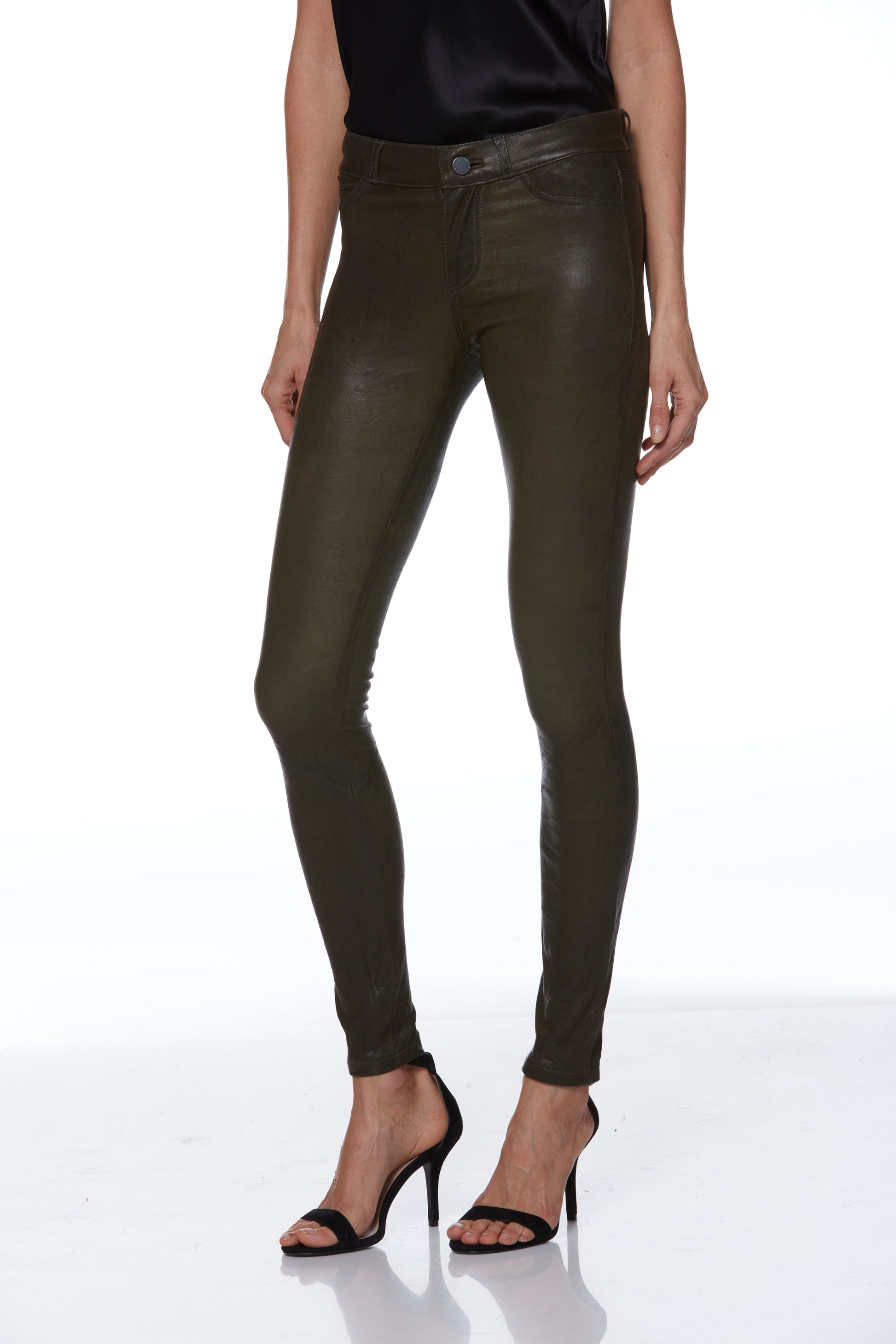 Person wearing olive green leather pants on a white background