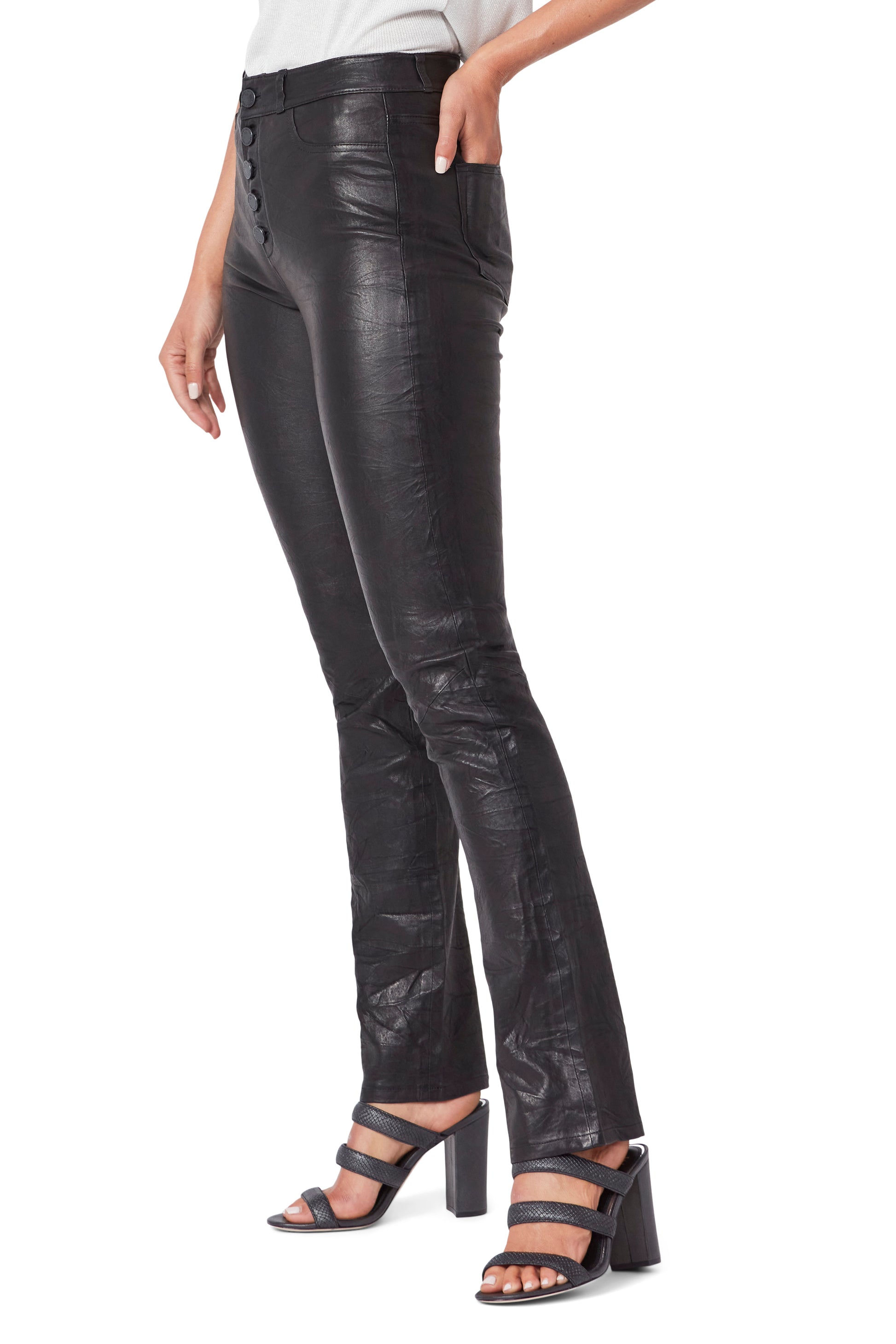 Black leather pants worn by a person on a white background