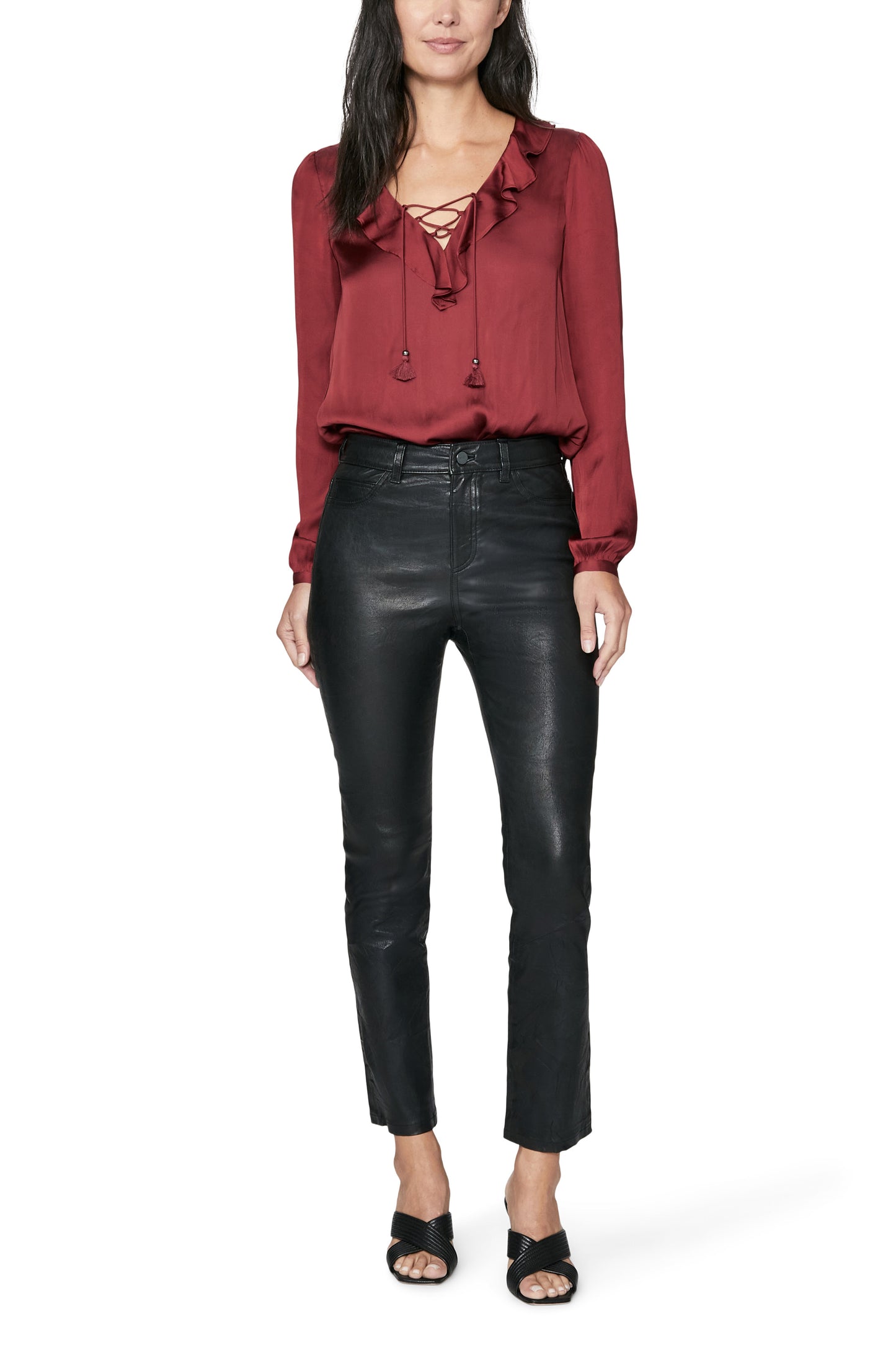 Woman wearing a red blouse and black leather pants on a white background