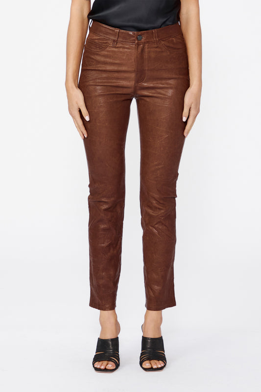 Brown leather pants worn by a person on a white background