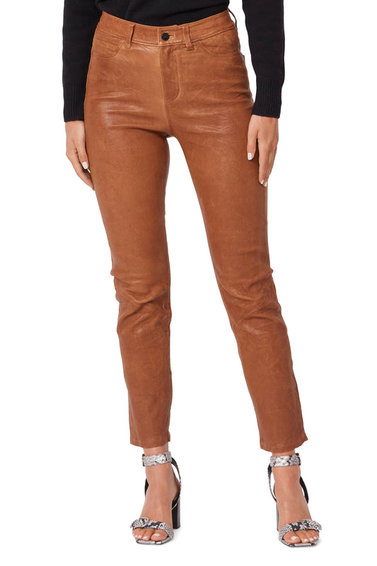 Brown leather pants worn by a person on a white background
