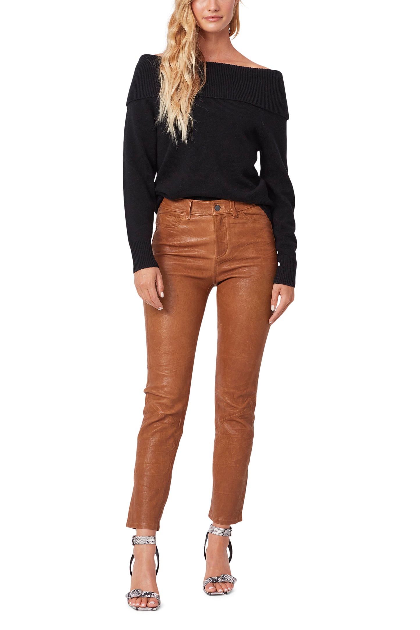 Woman wearing a black off-shoulder top and brown leather pants on a white background