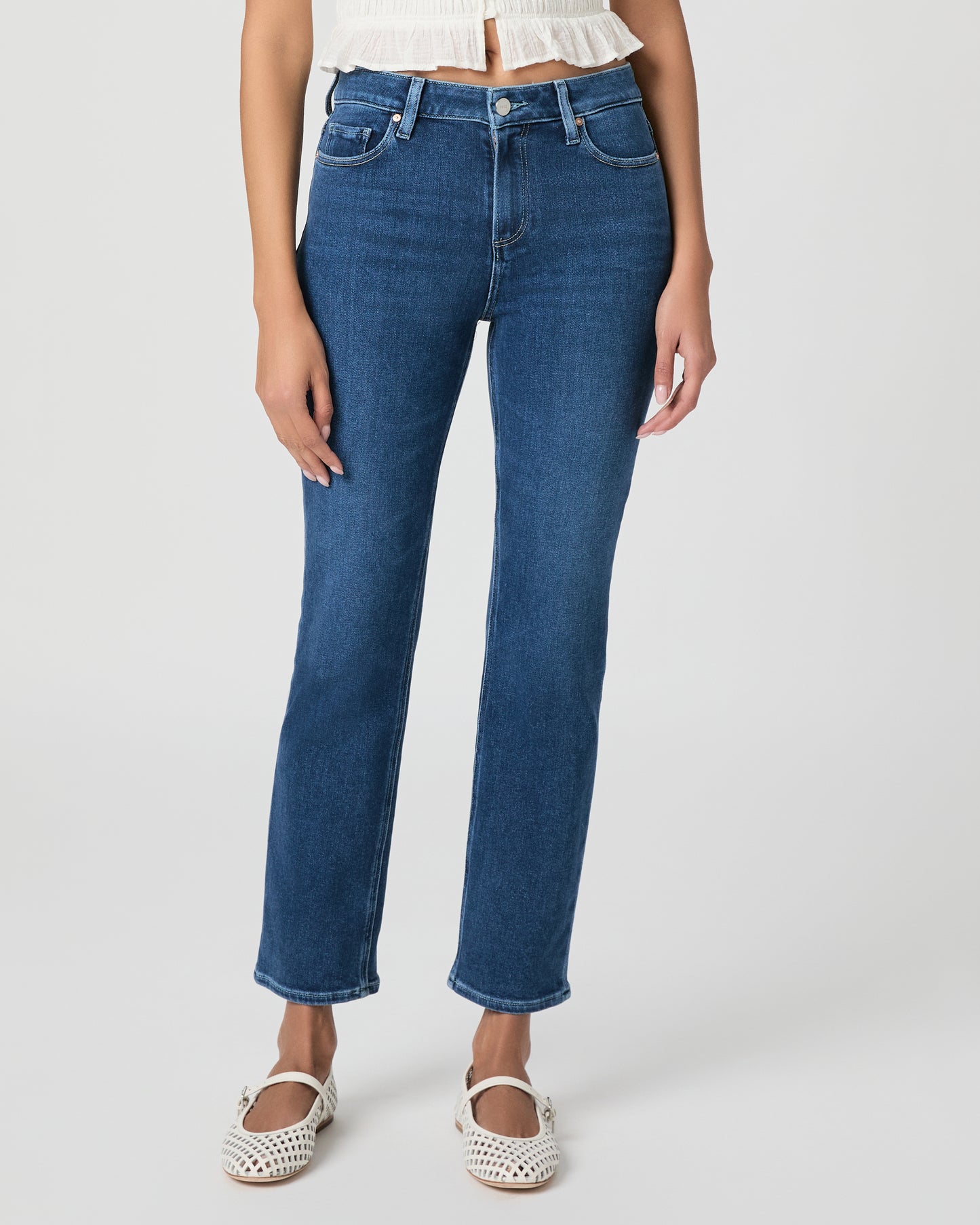 Woman wearing a white blouse and blue jeans on a white background