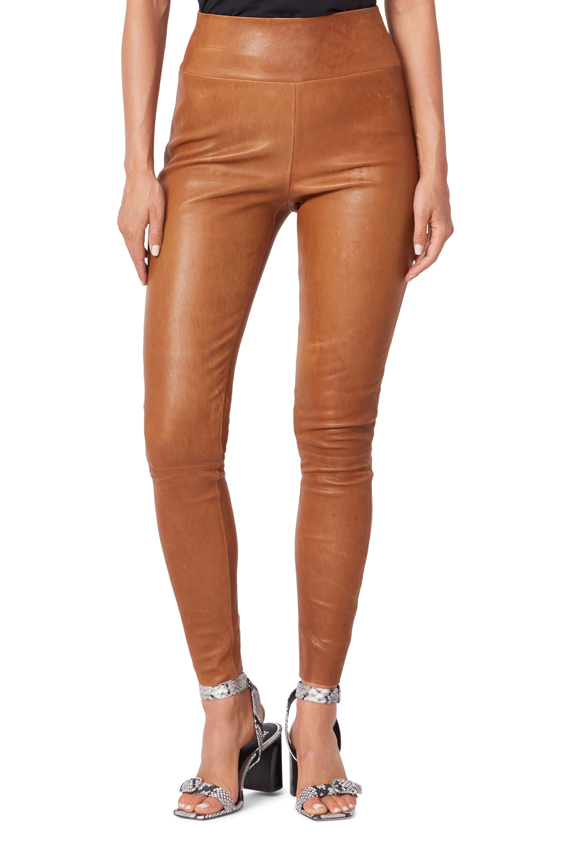 Tan leather leggings worn by a model on a white background