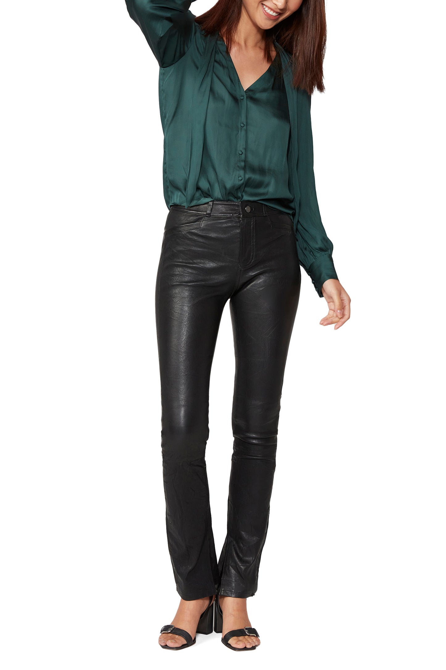 Woman wearing a green blouse and black leather pants on a white background