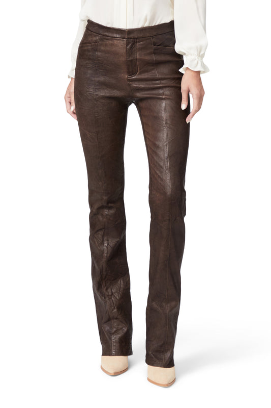 Brown leather pants worn by a person on a white background