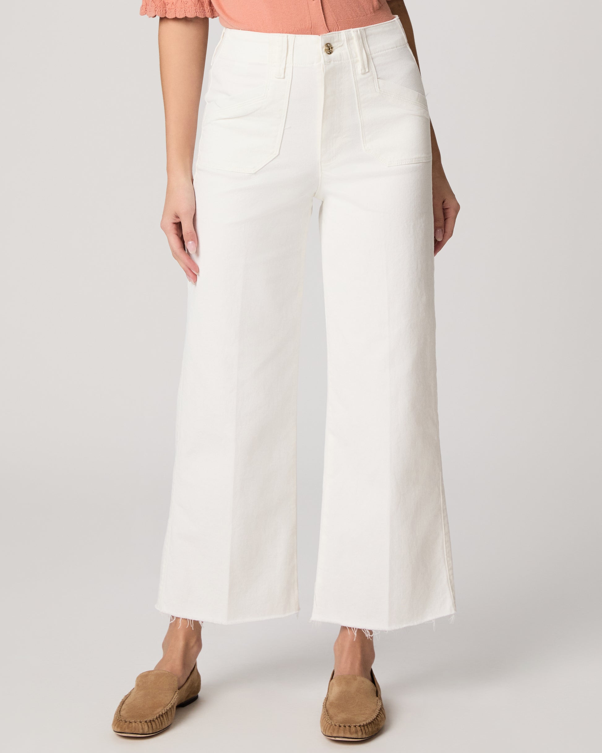 Person wearing white wide-leg pants on a plain background