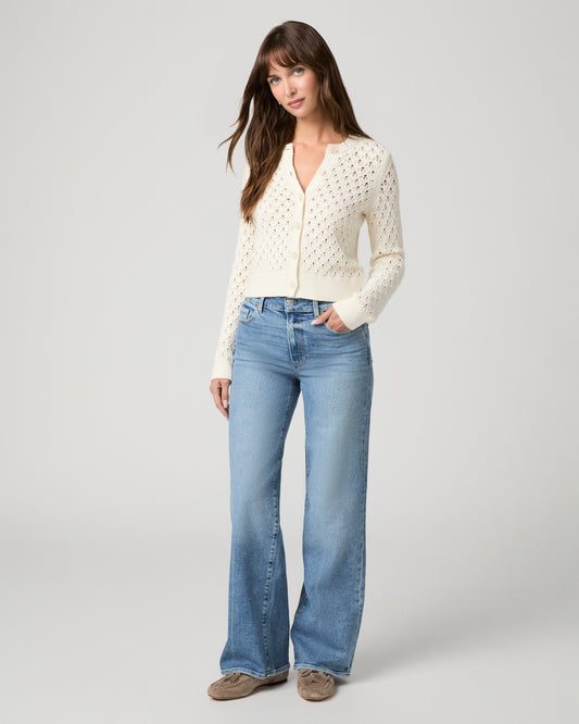 Woman in a white top with light blue jeans and a white background