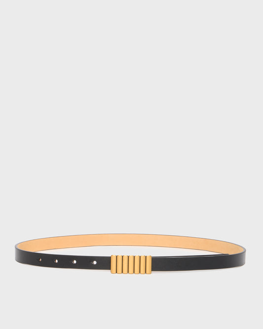 A minimalist black leather belt with a wide tan interior lining and a central gold-toned textured rectangular buckle, displayed horizontally on a light gray background.