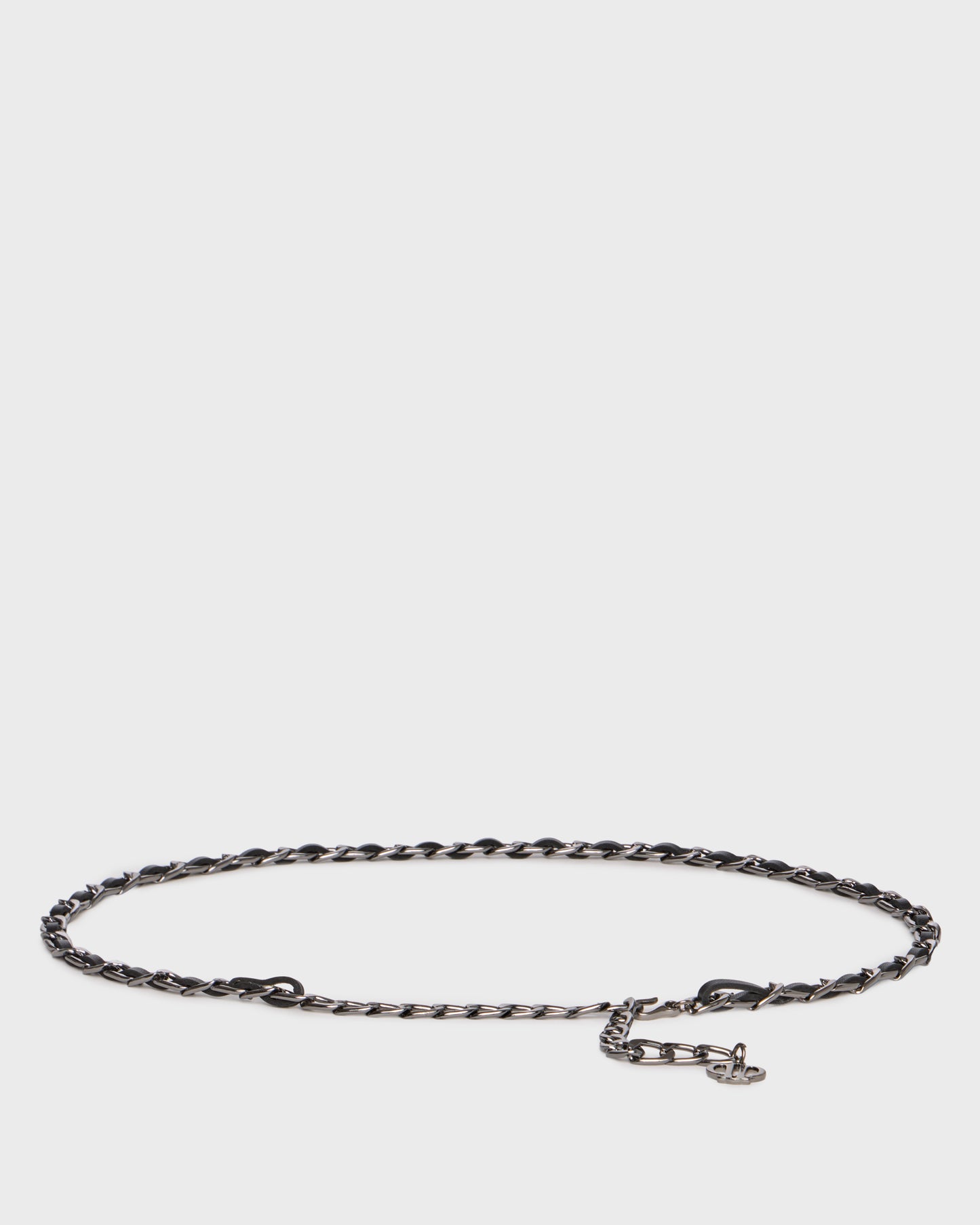 A dark metallic chain link bracelet with a small lobster clasp and a tiny charm, displayed on a light gray background.