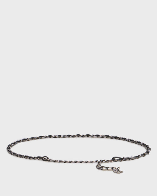 A dark metallic chain link bracelet with a small lobster clasp and a tiny charm, displayed on a light gray background.