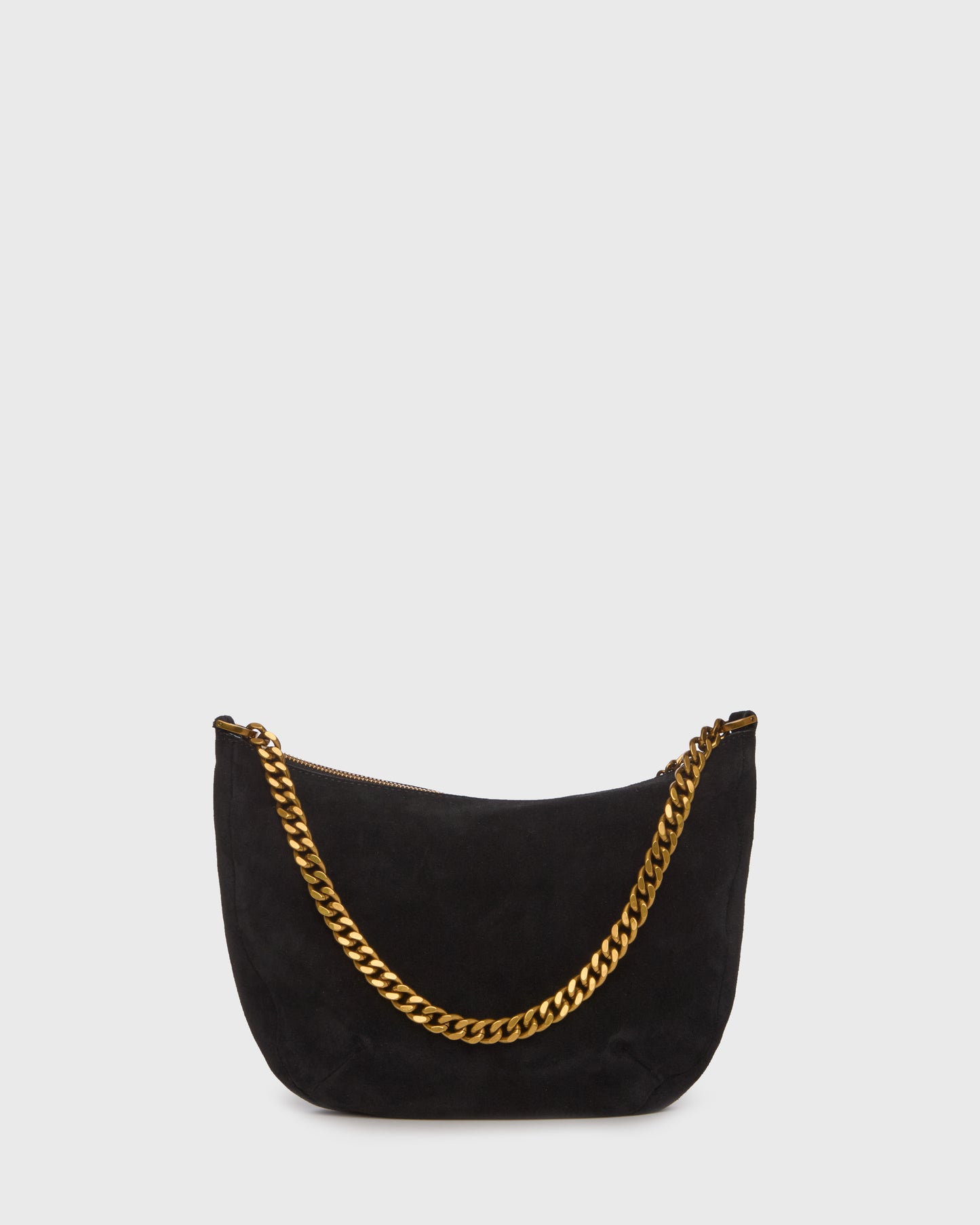 A black suede crescent-shaped shoulder bag with a gold-tone chain strap and a small gold logo charm, set against a plain light gray background.