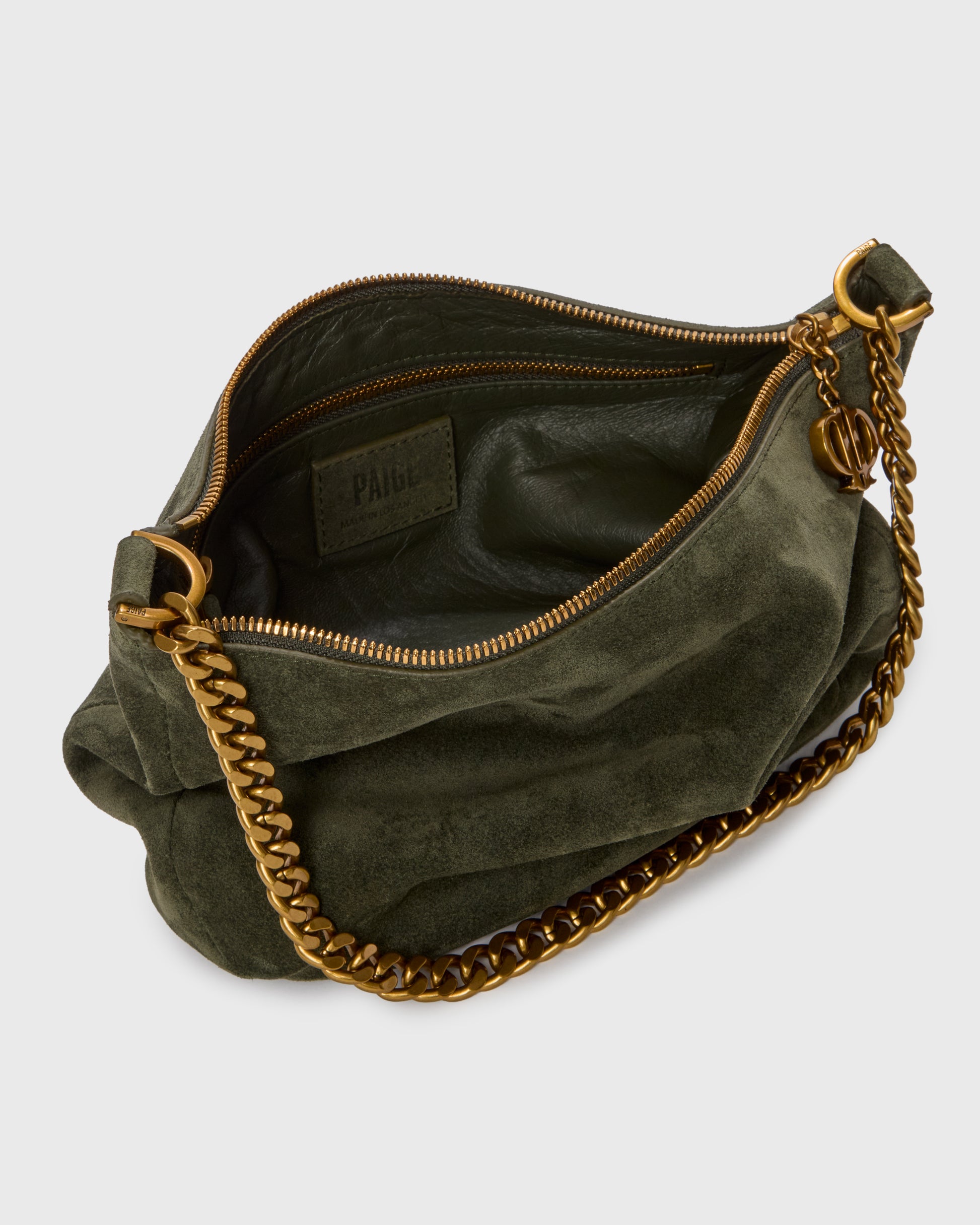 An olive green suede crescent-shaped shoulder bag with a gold-tone chain strap and a small gold logo charm, set against a plain light gray background.