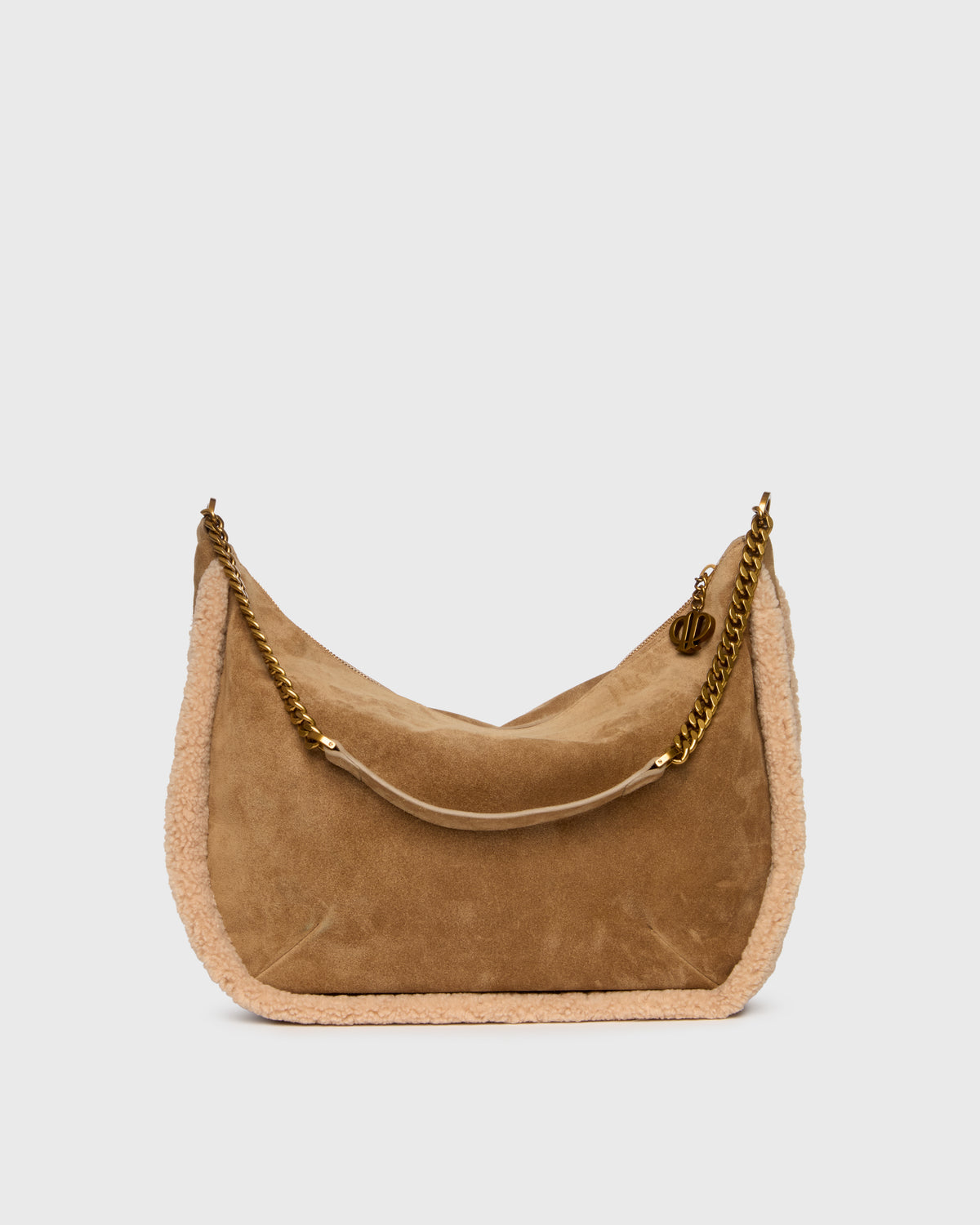 A crescent-shaped shoulder bag in tan suede with a light beige shearling lining and a gold-tone chain strap, shown against a light gray background.