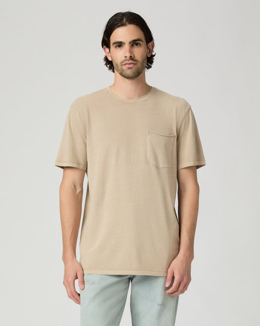 Men wearing a tan color tee with light blue jeans