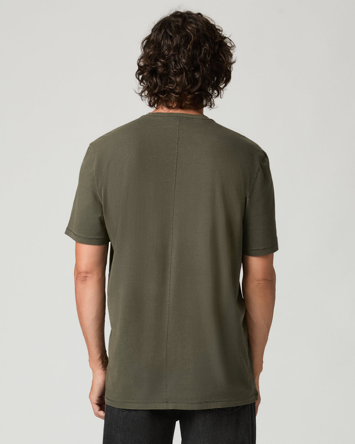 Back view of a man wearing the vintage fatigue green Ramirez Tee, highlighting the center back seam and raw-edge sleeve hems.