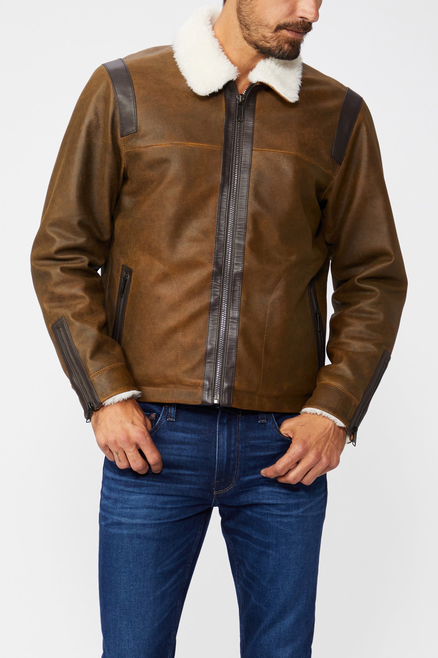 Brown leather jacket with white fur collar and blue jeans on a white background