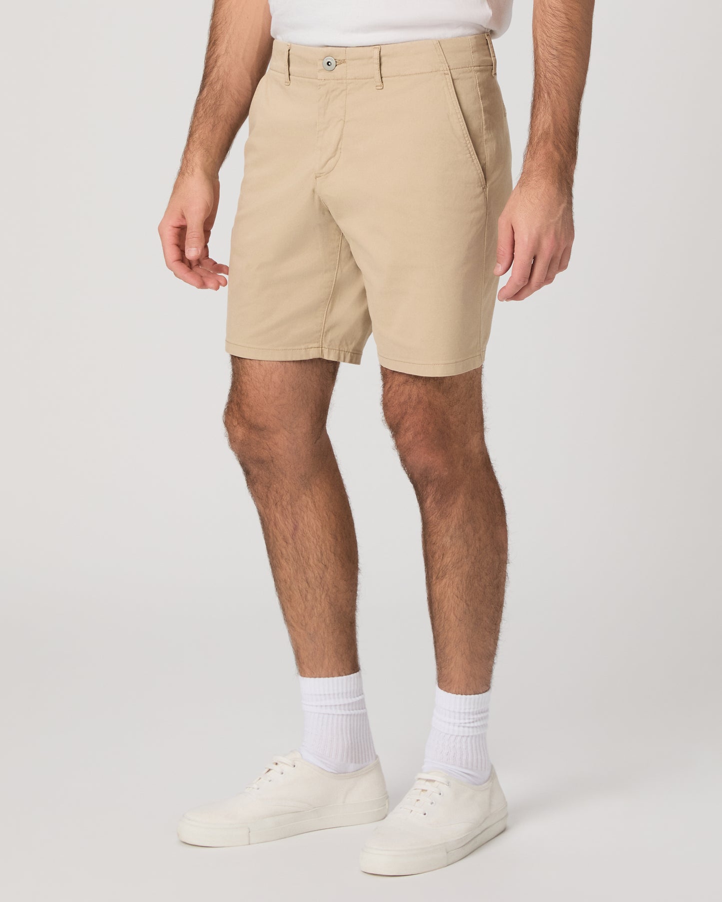 Men wearing beige color shorts paired with a white tee and white sneakers