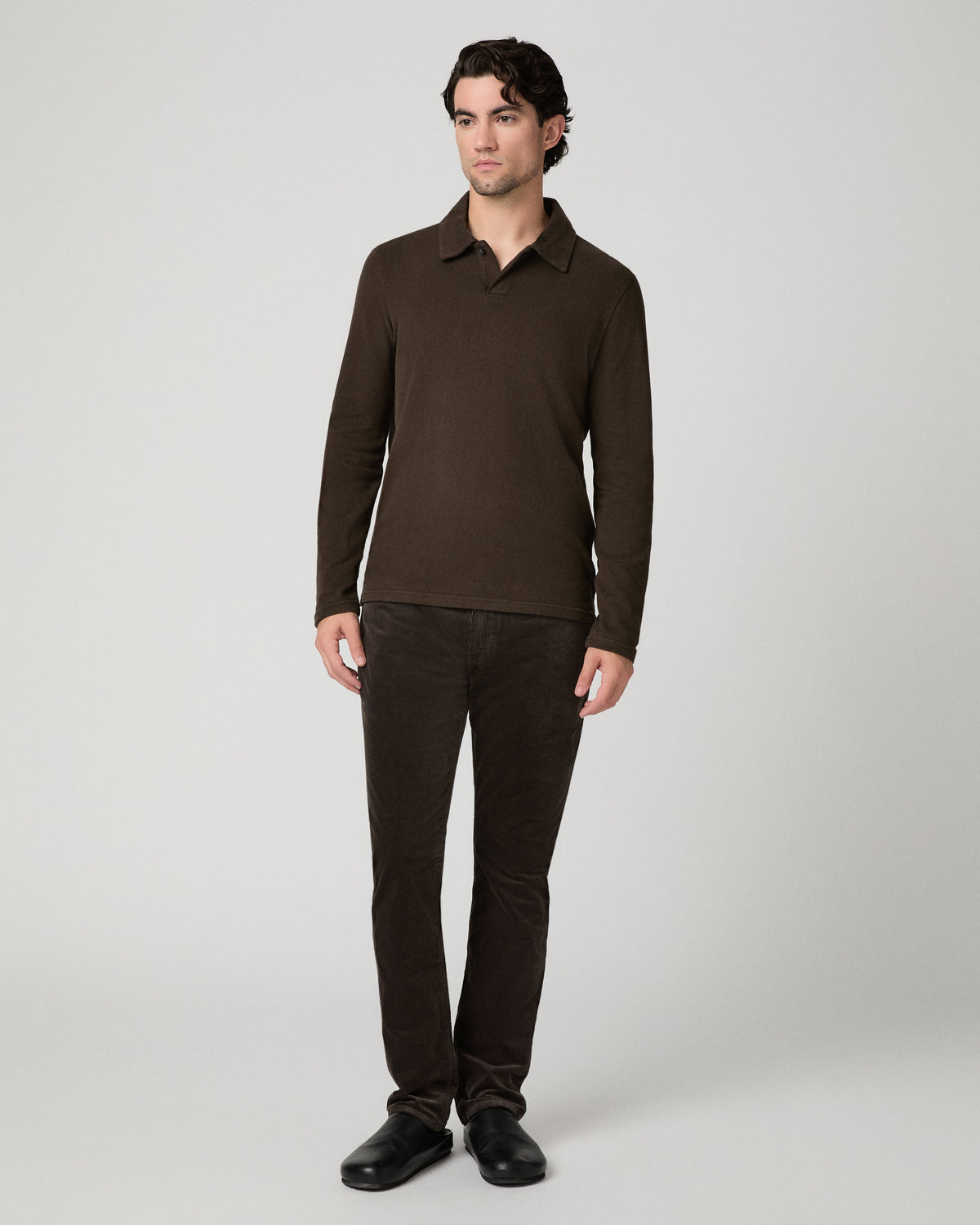 Man wearing a brown shirt and brown pants against a white background