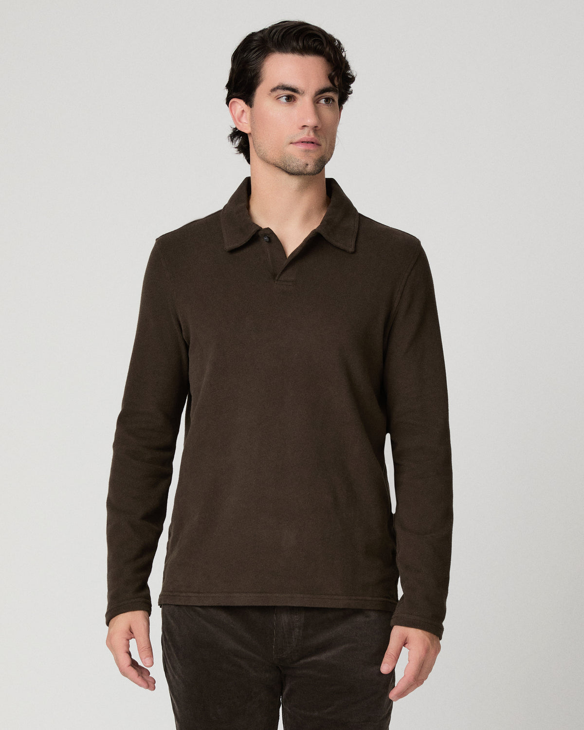 Man wearing a brown shirt and brown pants against a white background
