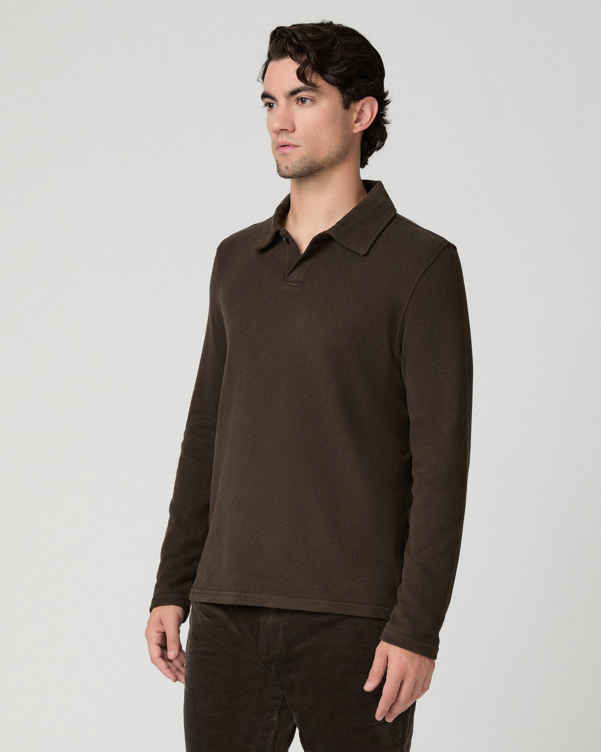 Man wearing a brown shirt and brown pants against a white background