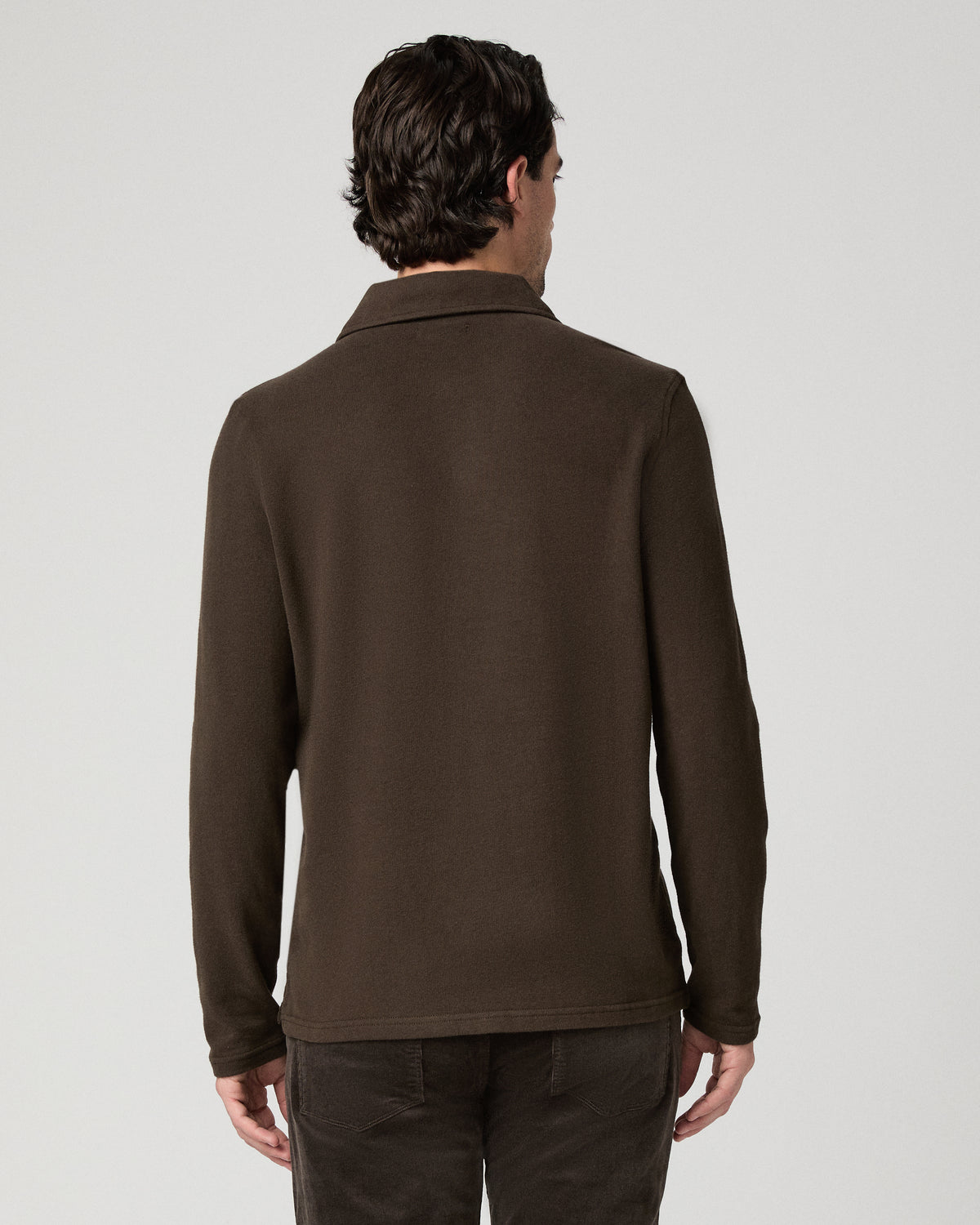 Man wearing a brown shirt and brown pants against a white background