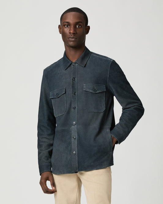 Man wearing a dark blue jacket with button details on a light gray background