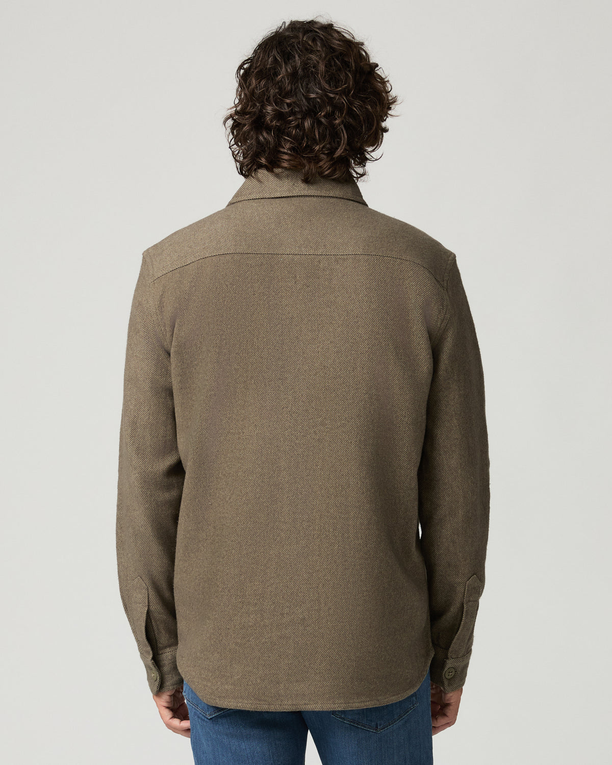 Rear view of the man wearing the moss green Seymore overshirt, showing the back yoke and relaxed tailored fit.