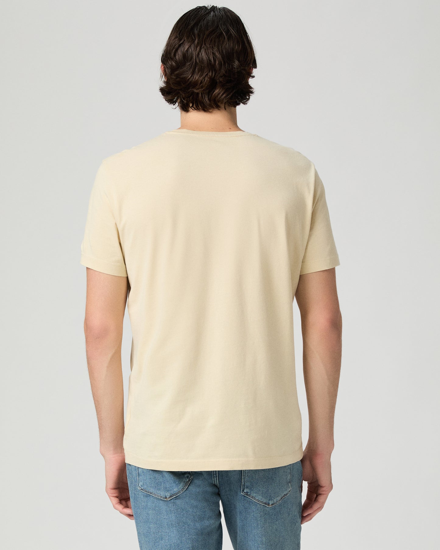 Man wearing light yellow with a medium wash jeans