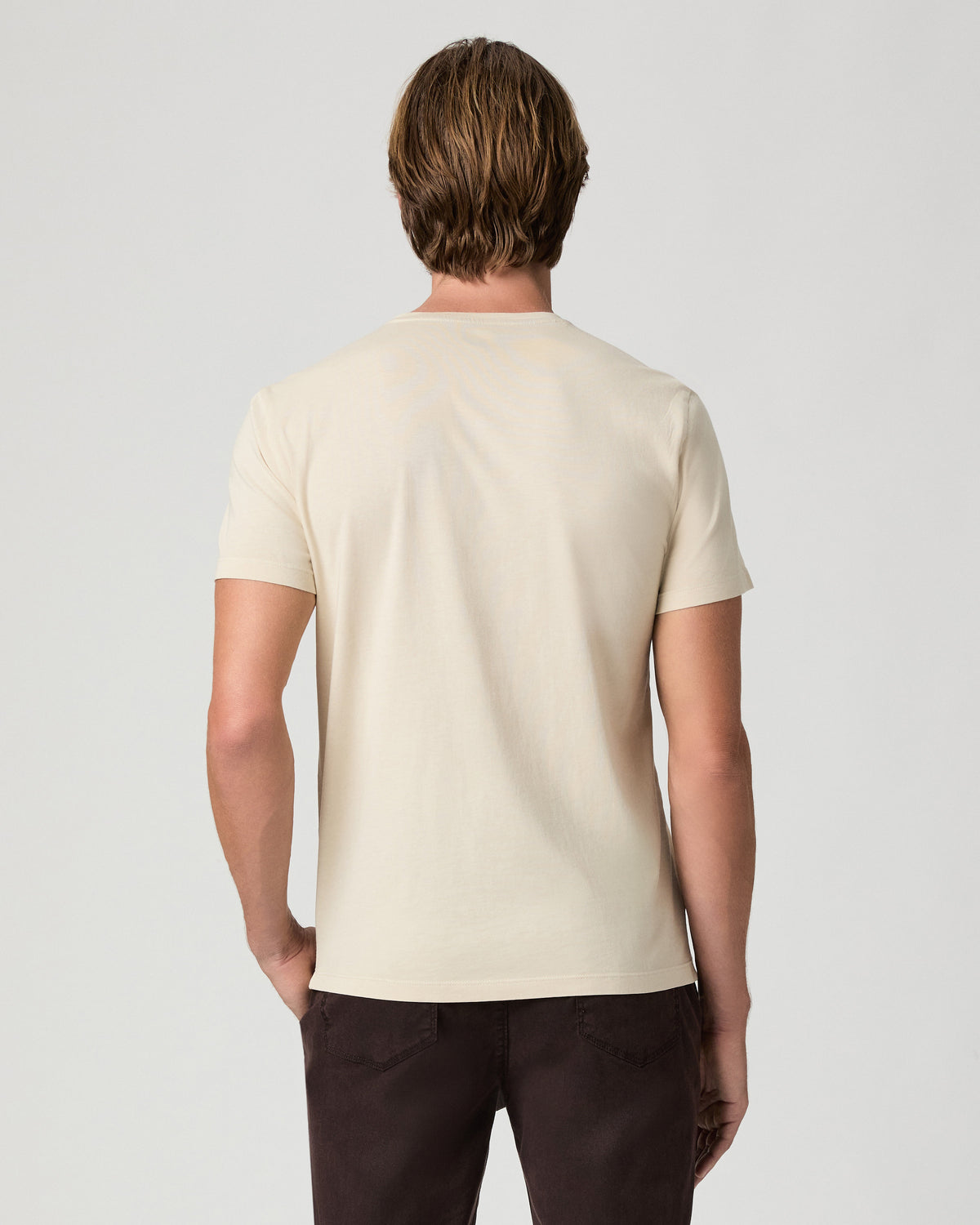 Back view of model wearing the Sorden Crew Neck Tee in Light Pale Antler with dark brown pants