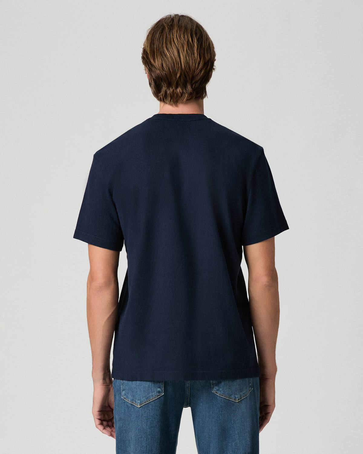Back view of model wearing the Serano Boxy Tee in Hibernate with medium-wash jeans