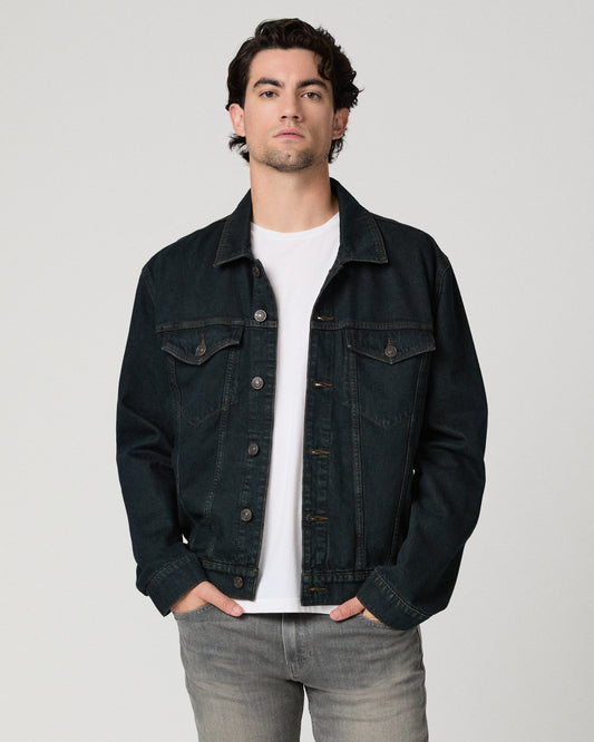 Man wearing white shirt with a dark blue jacket and grey jeans