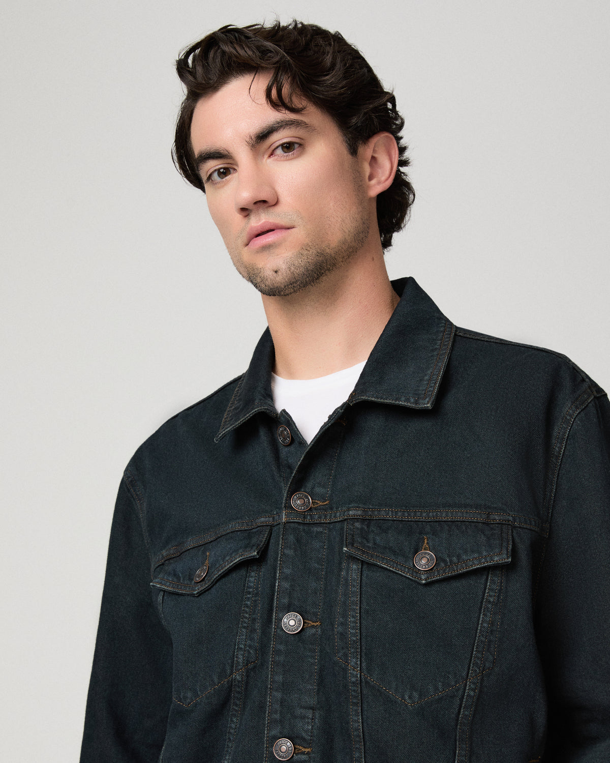 Man wearing white shirt with a dark blue jacket against a white background