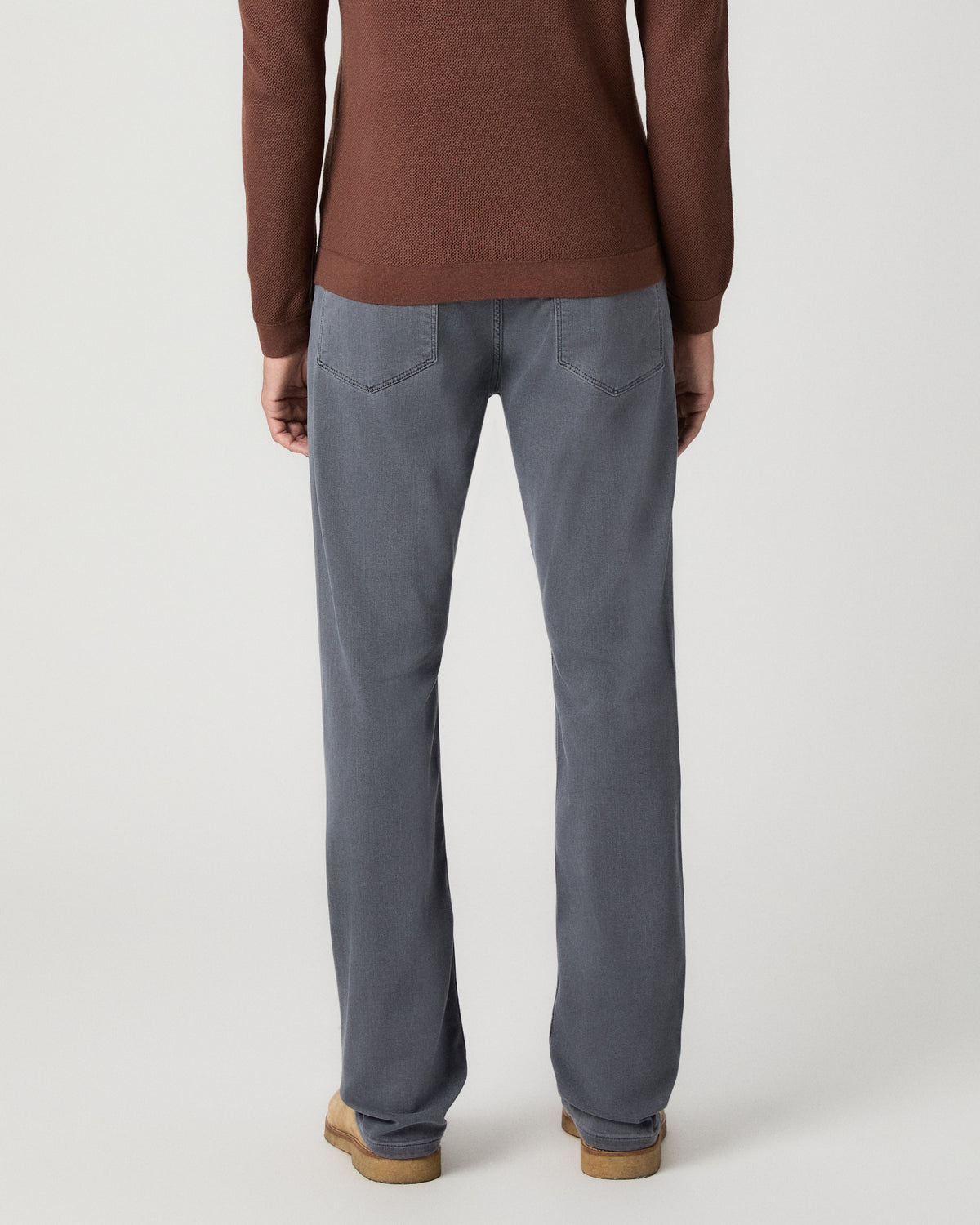 Back view of model wearing the Selwyn Sweater Polo in Sorrel with grey jeans
