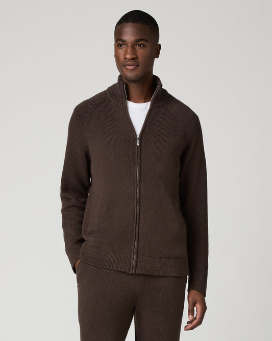 Full-length front view of a man wearing a chocolate brown zip-up cardigan with a stand collar over a white t-shirt, paired with matching brown sweatpants, arms relaxed at his sides.