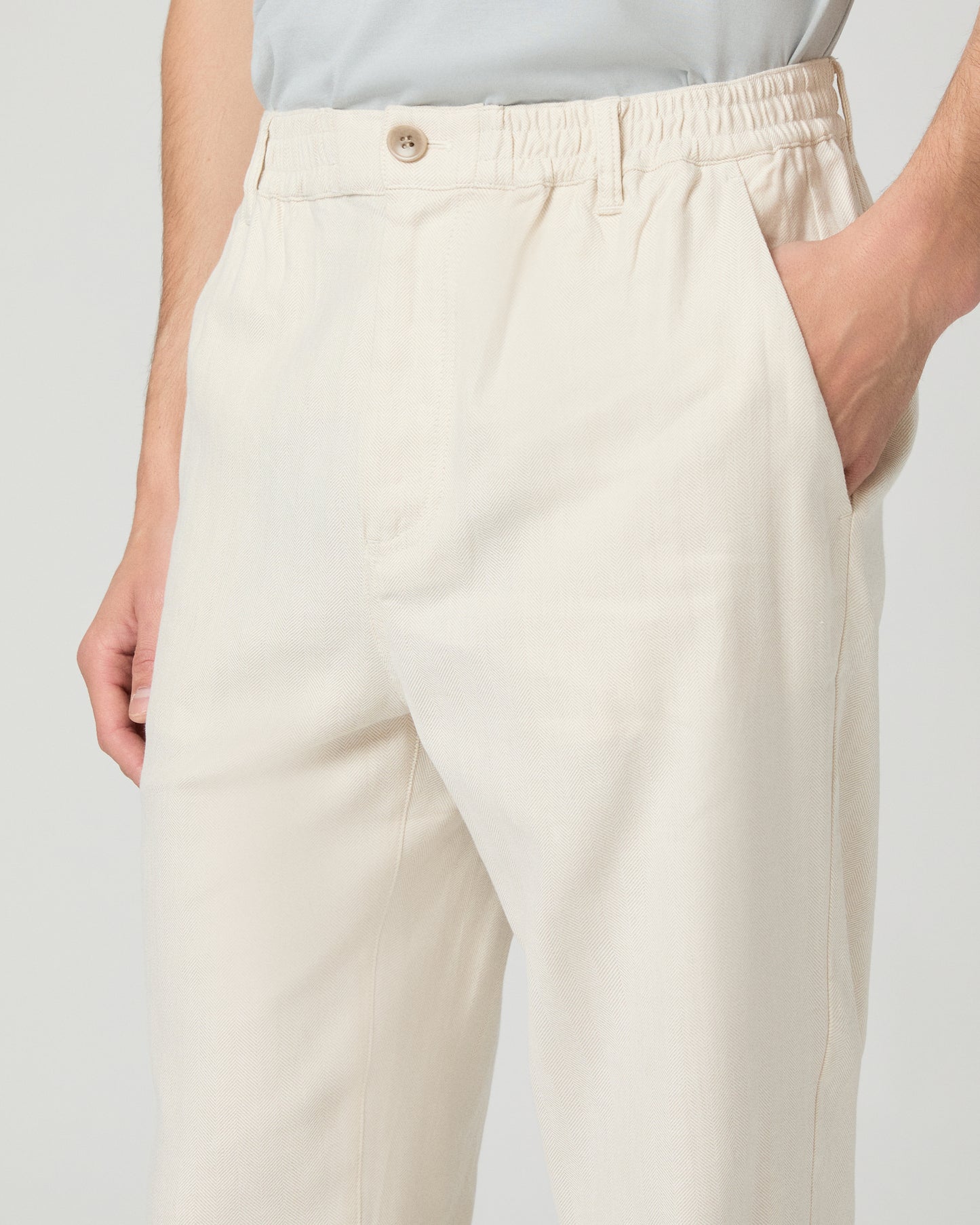 Man wearing a white tee, beige pants on a white background