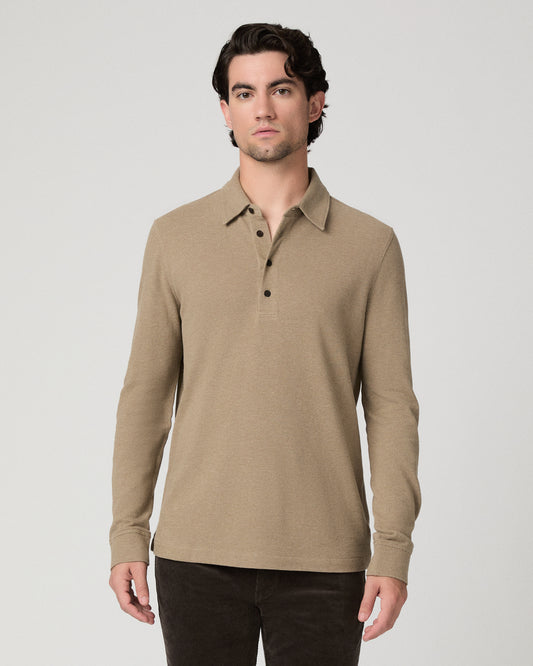 Man wearing beige top and brown pants against a white background