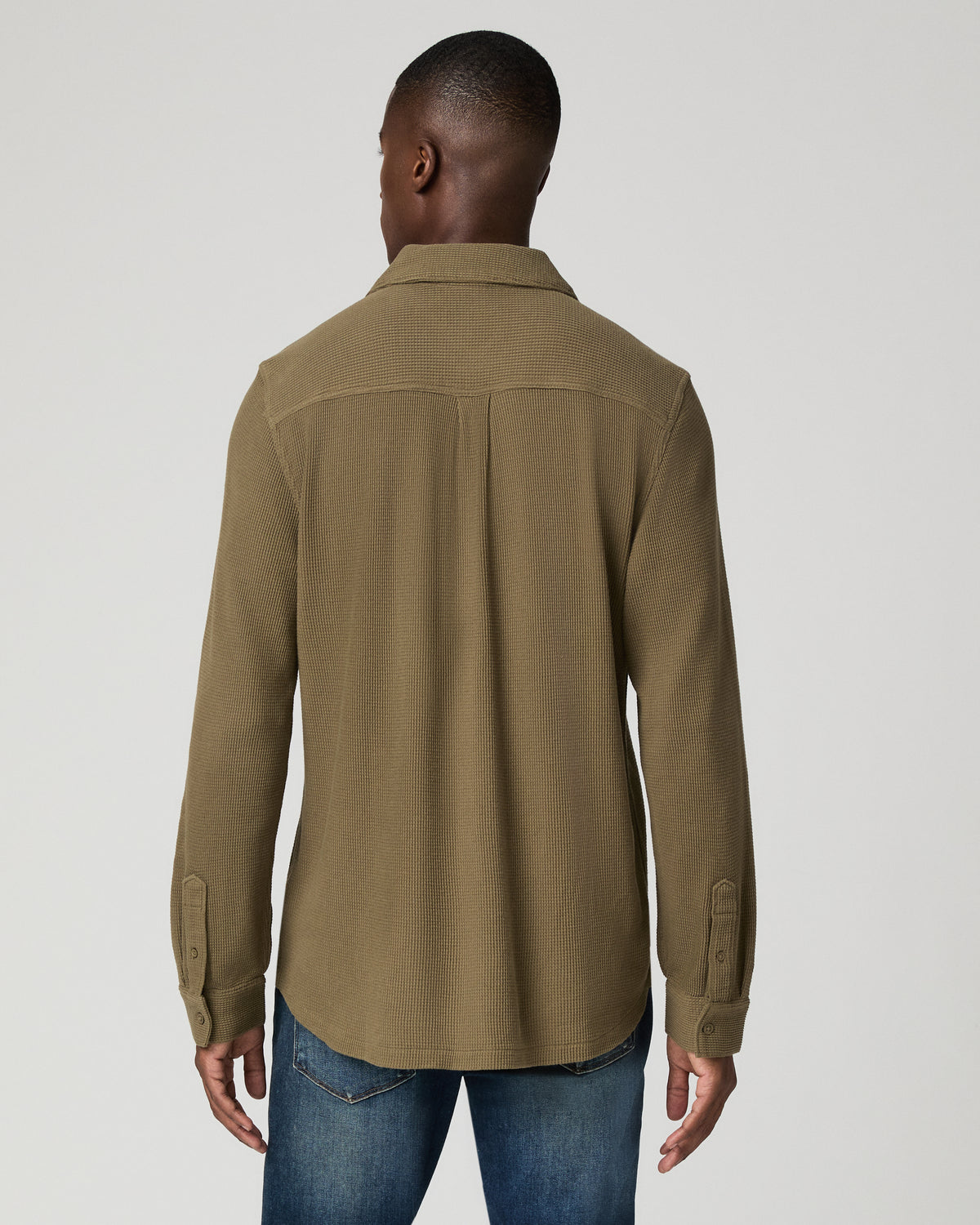 Close-up back view of a man wearing the deep olive green waffle-knit shirt, showing the back yoke seam and textured knit fabric.
