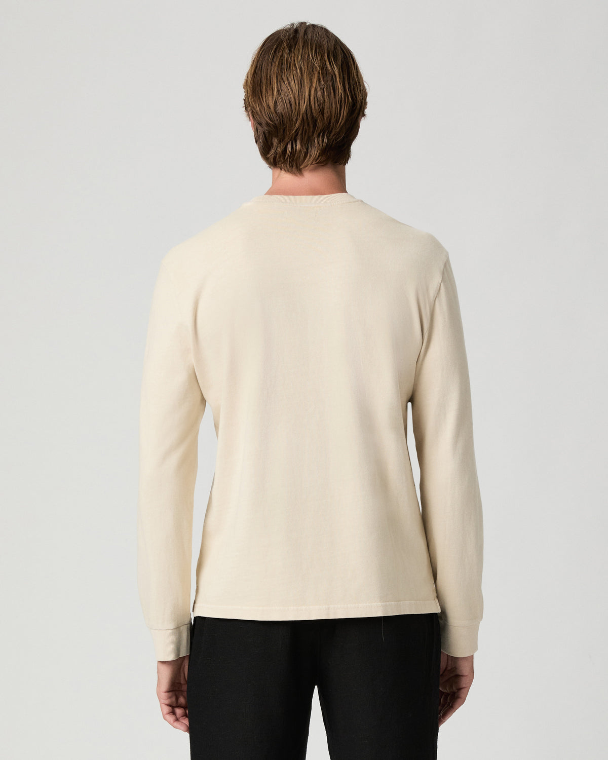 Back view of model wearing the Norcross Long Sleeve Boxy Tee in Pale Antler with black pants