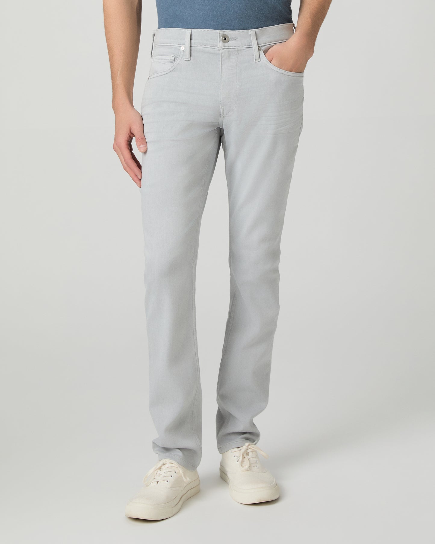 Man wearing a blue t-shirt and gray pants on a white background