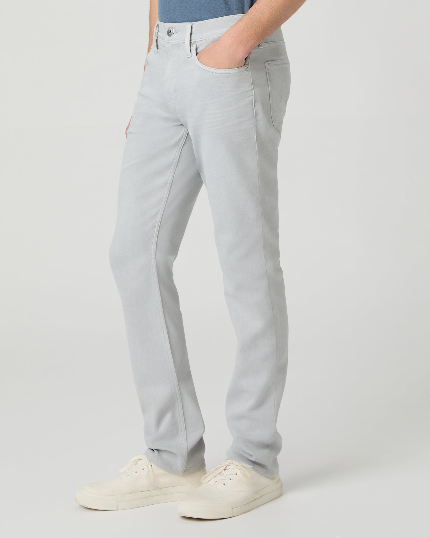 Man wearing a blue t-shirt and gray pants on a white background