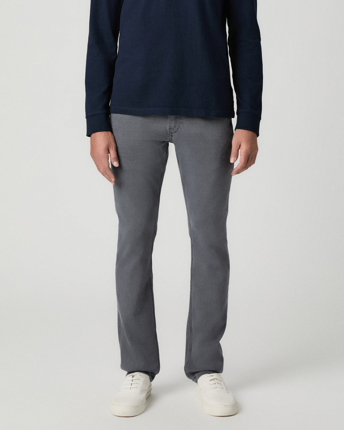 Front view from the waist down of the Lennox 32 Inch Slim Jean in Vintage Icy River, a grey wash, worn with a navy long-sleeve top and white sneakers
